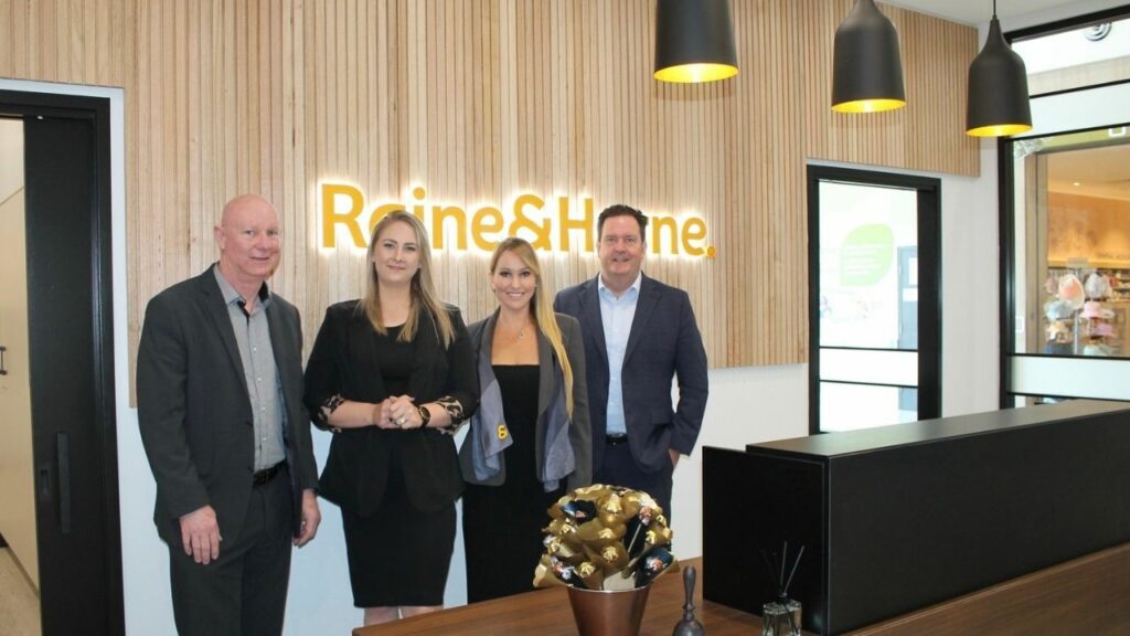 Picture of four people standing in real estate office