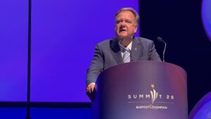Barfoot & Thompson Managing Director Peter Thompson speaking at a lectern branded Summit 26 in Auckland