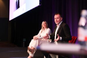 Pamela Medeiros and Bradley Fraser speaking at PM/ONE 2026