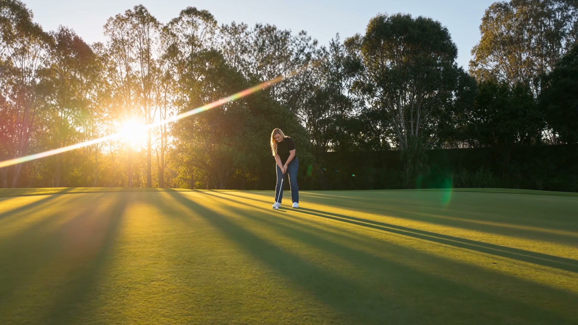 Person swinging a golf club beside a home near the course, symbolising the lifestyle a buyer imagines living there